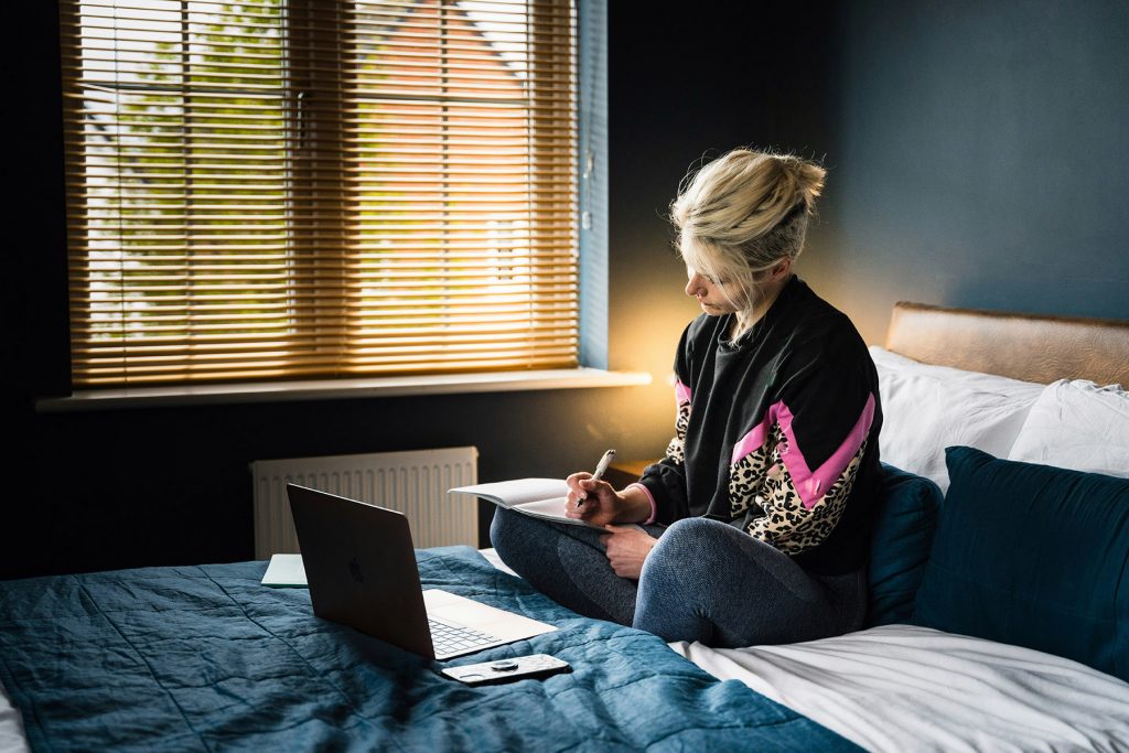 woman on bed writing
